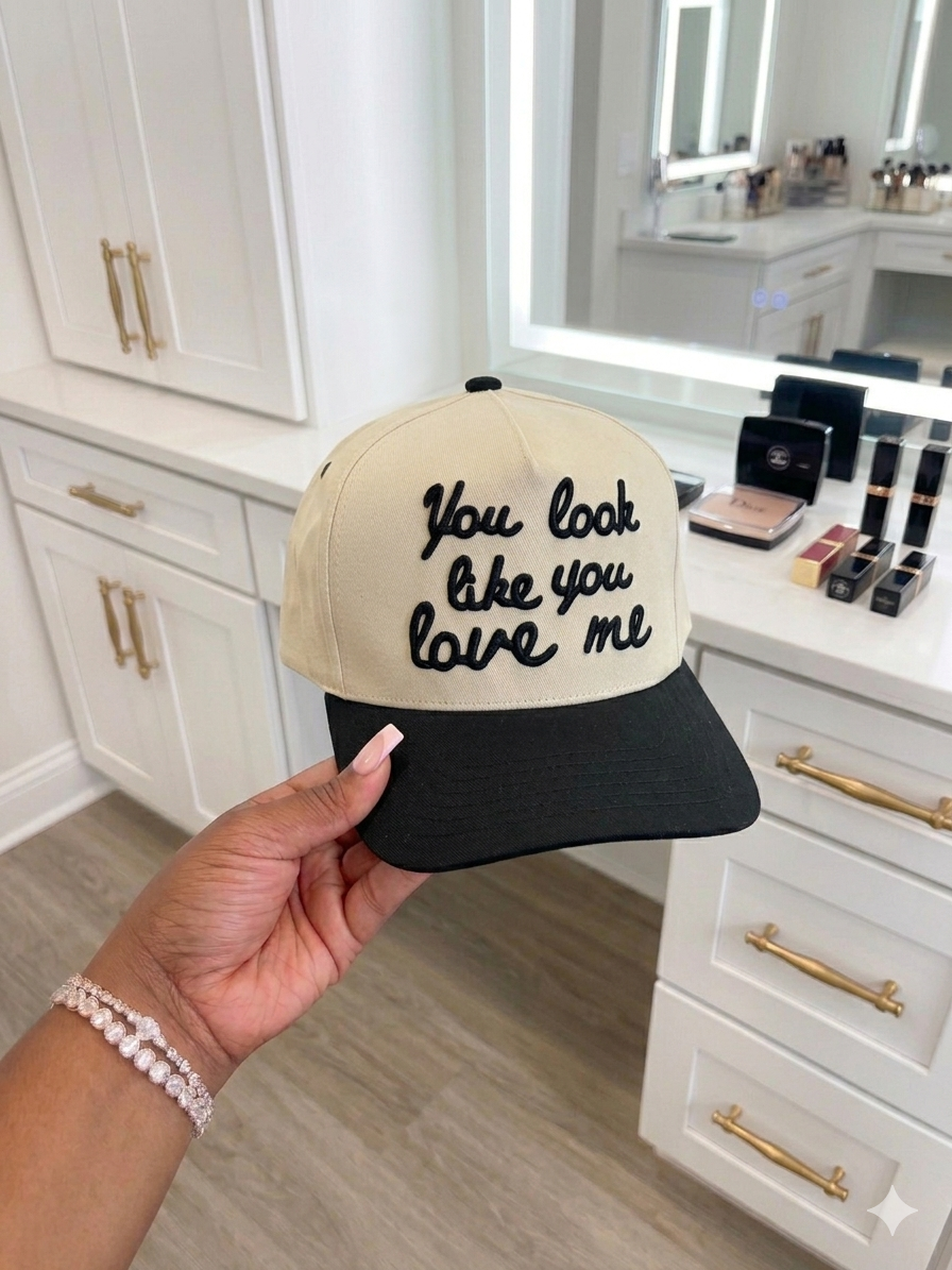 Cream and black snapback hat with You look like you love me script embroidery